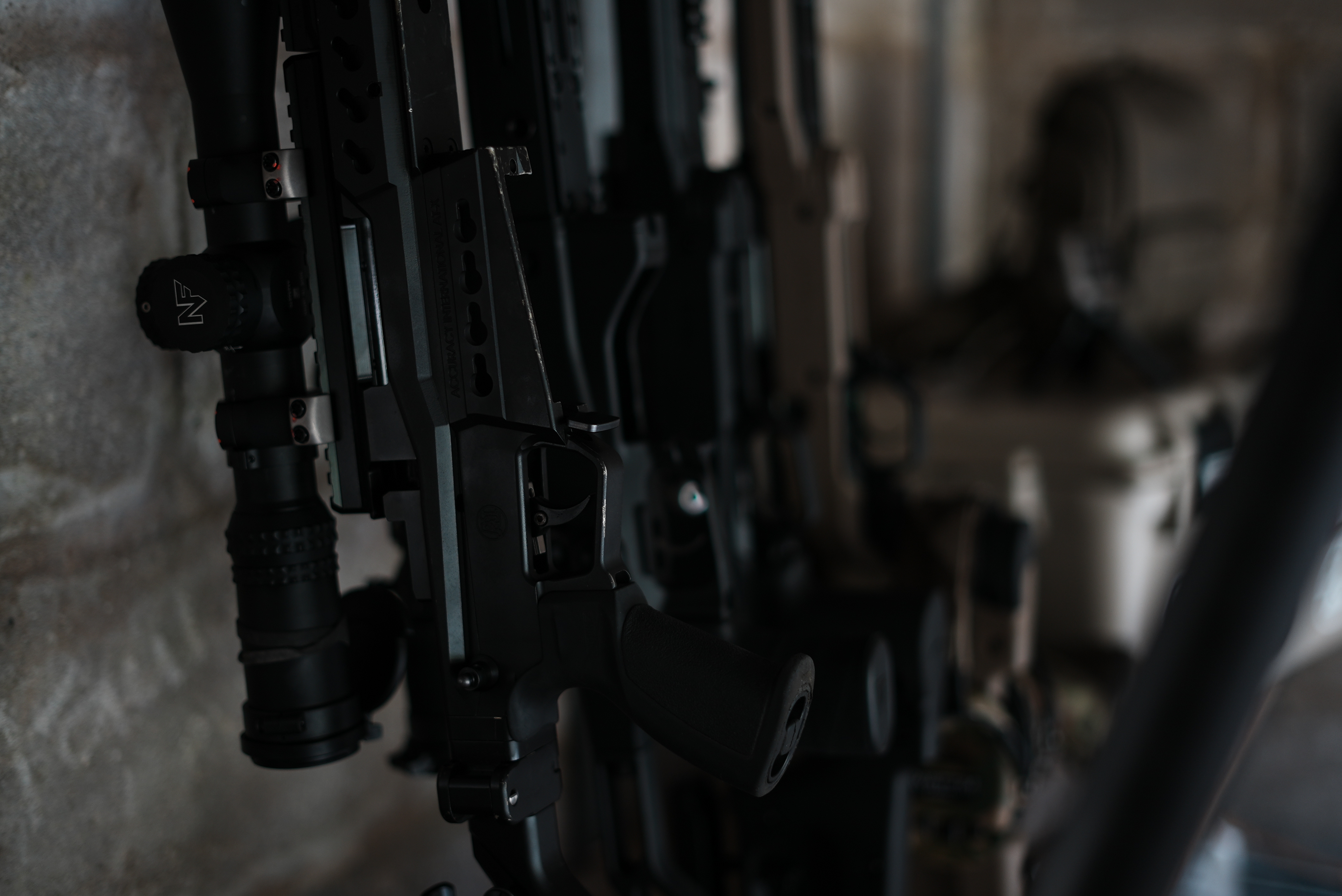 Firearms arm hero. Single strong still: instructor working, kit in use, or environmental wide. Not posed.